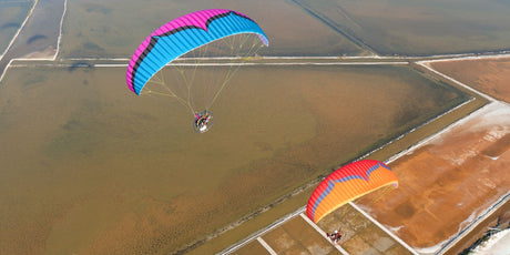 two parajets flying over fields