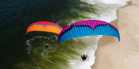 two parajets flying over the shore