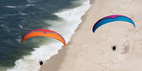 two parajets flying over the shore