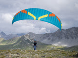 person in alps holding paramotor wing