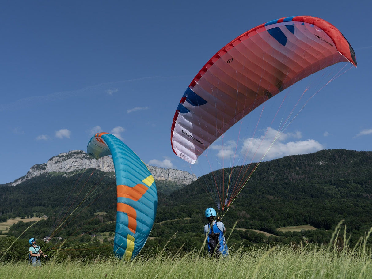 two people on ground holding paramotor wings