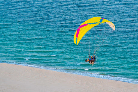 person flying parajet on a shoreline