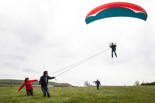 two people pulling paramotor strings on taster course